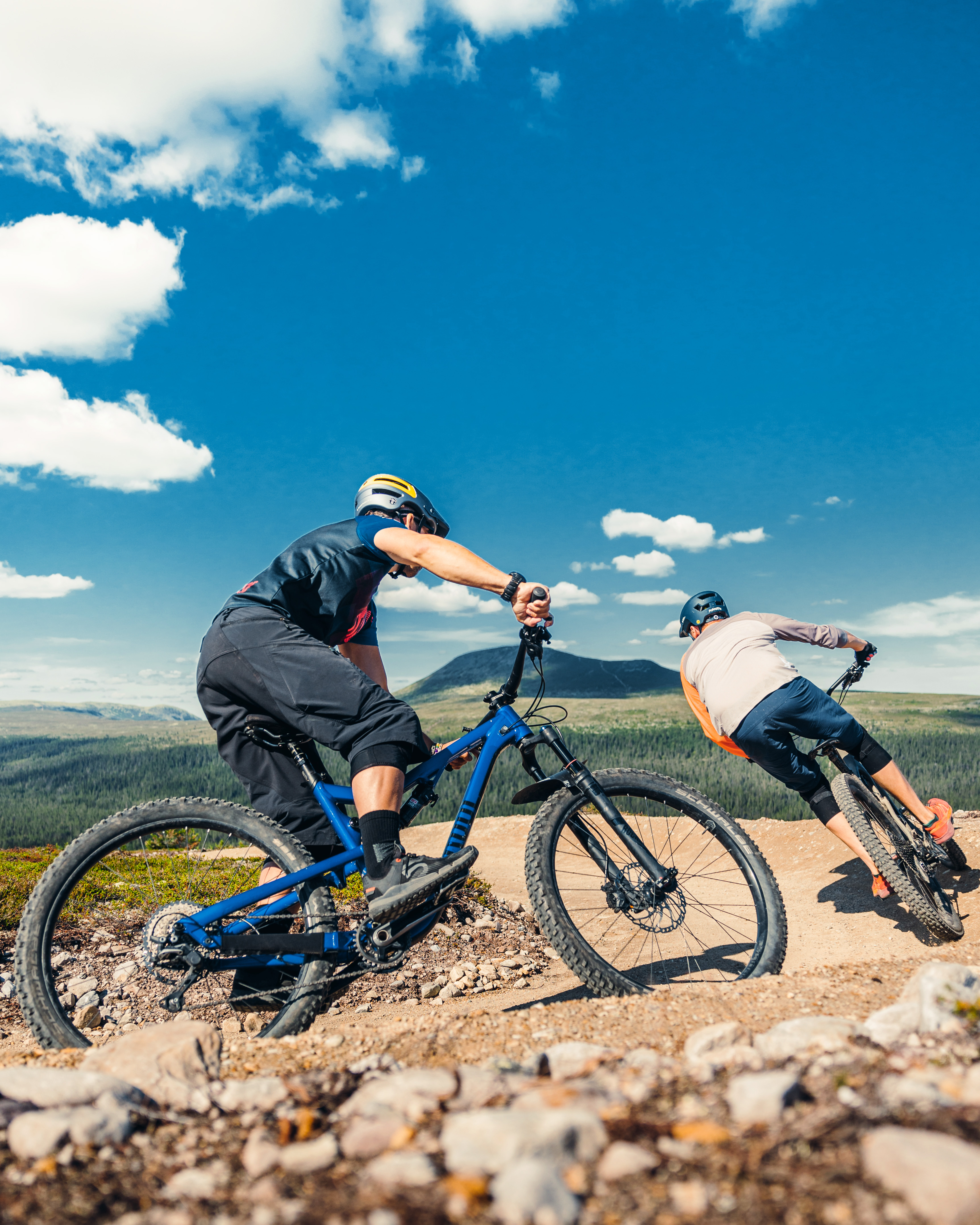 Två personer som cyklar på fjället med Städjan i bakgrunden.