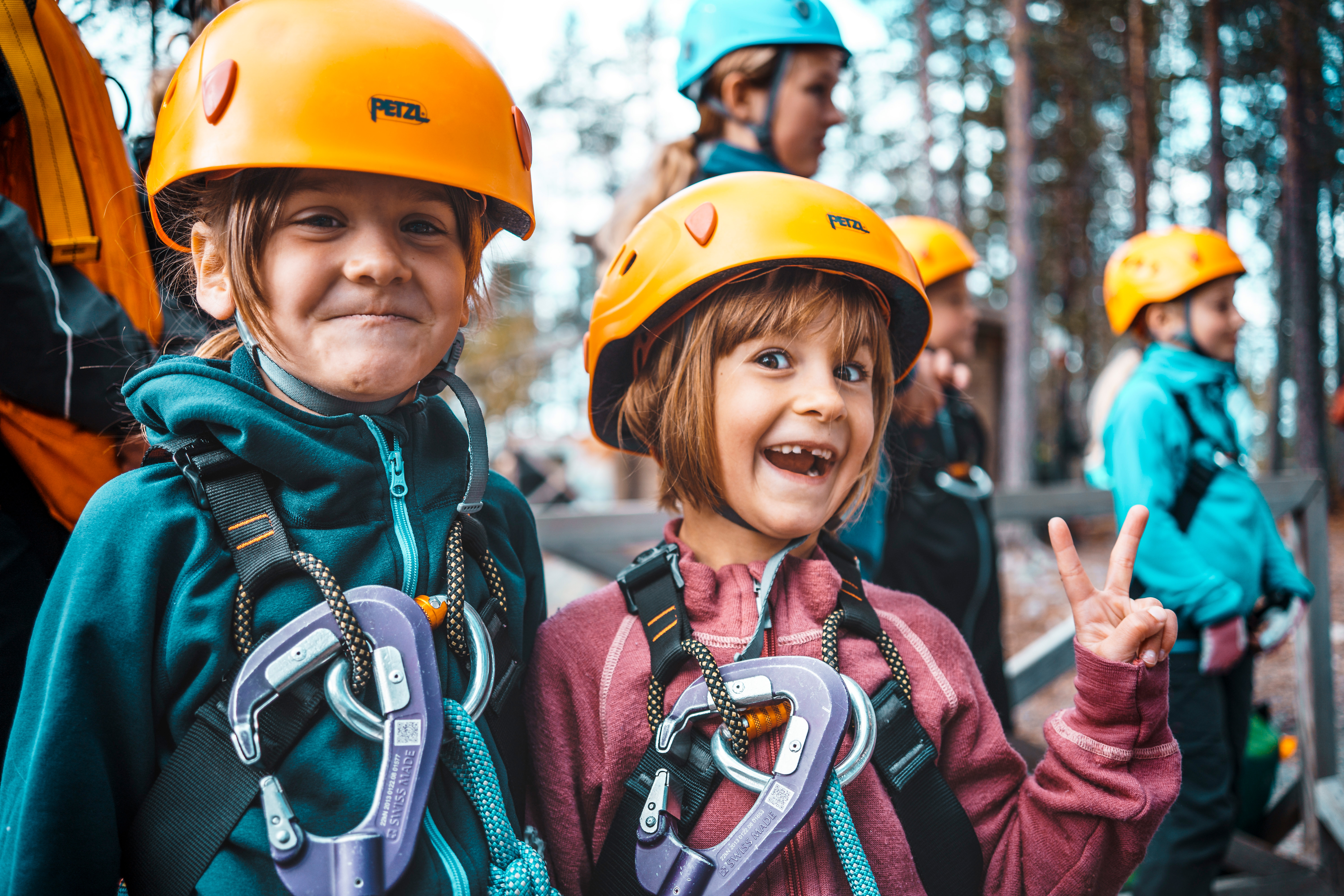 Två barn i förgrunden som är på väg till höghöjdbanan. Fler barn i bakgrunden.