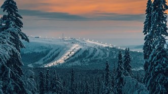 Idre Fjäll på kvällen från långt håll.  Skog i förgrunden.